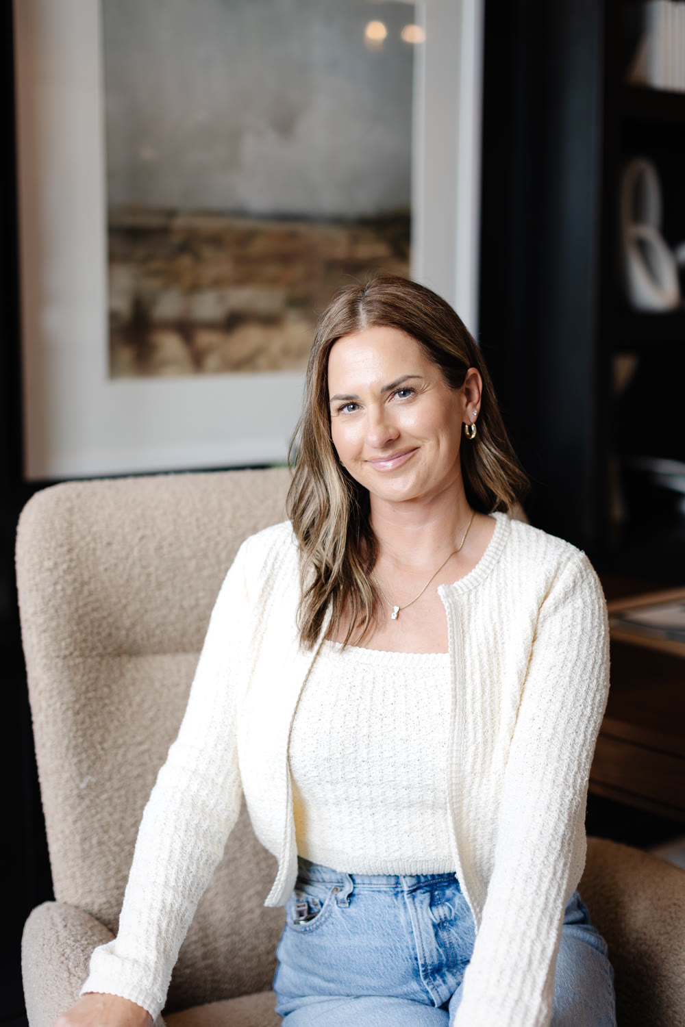 Whitney Wilkinson, East Valley real estate agent, smiling in a cream sweater